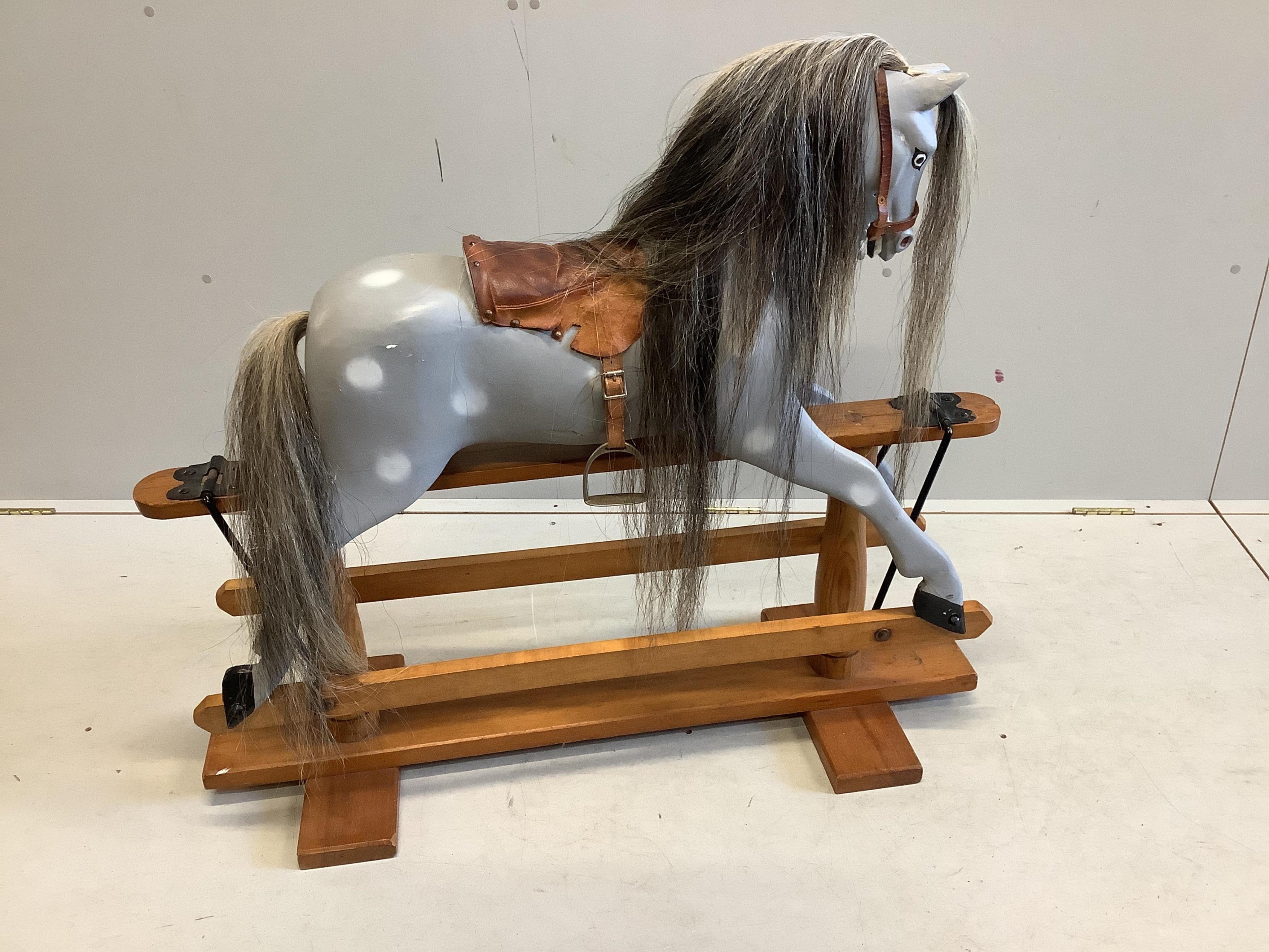 A small 1950's Ayers type dapple grey rocking horse on pine safety frame, later painted, width 106cm, height 95cm. Condition - fair